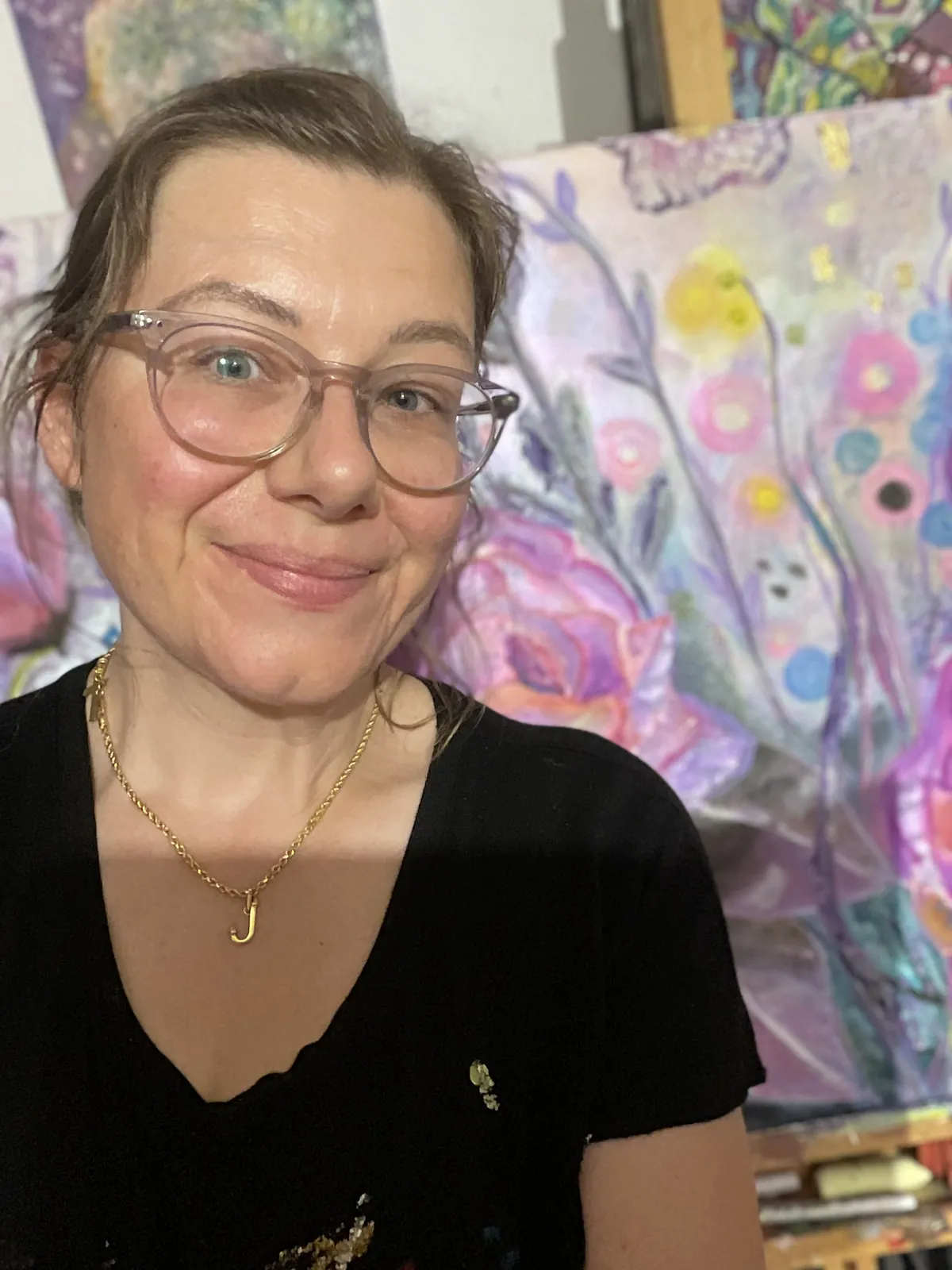 Artist Agata May'kowska smiling in her studio in front of the floral commission