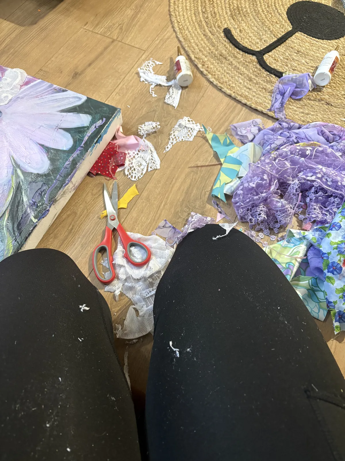 Cutting paper by hand for textured petals, with scissors and paper scraps on the studio floor