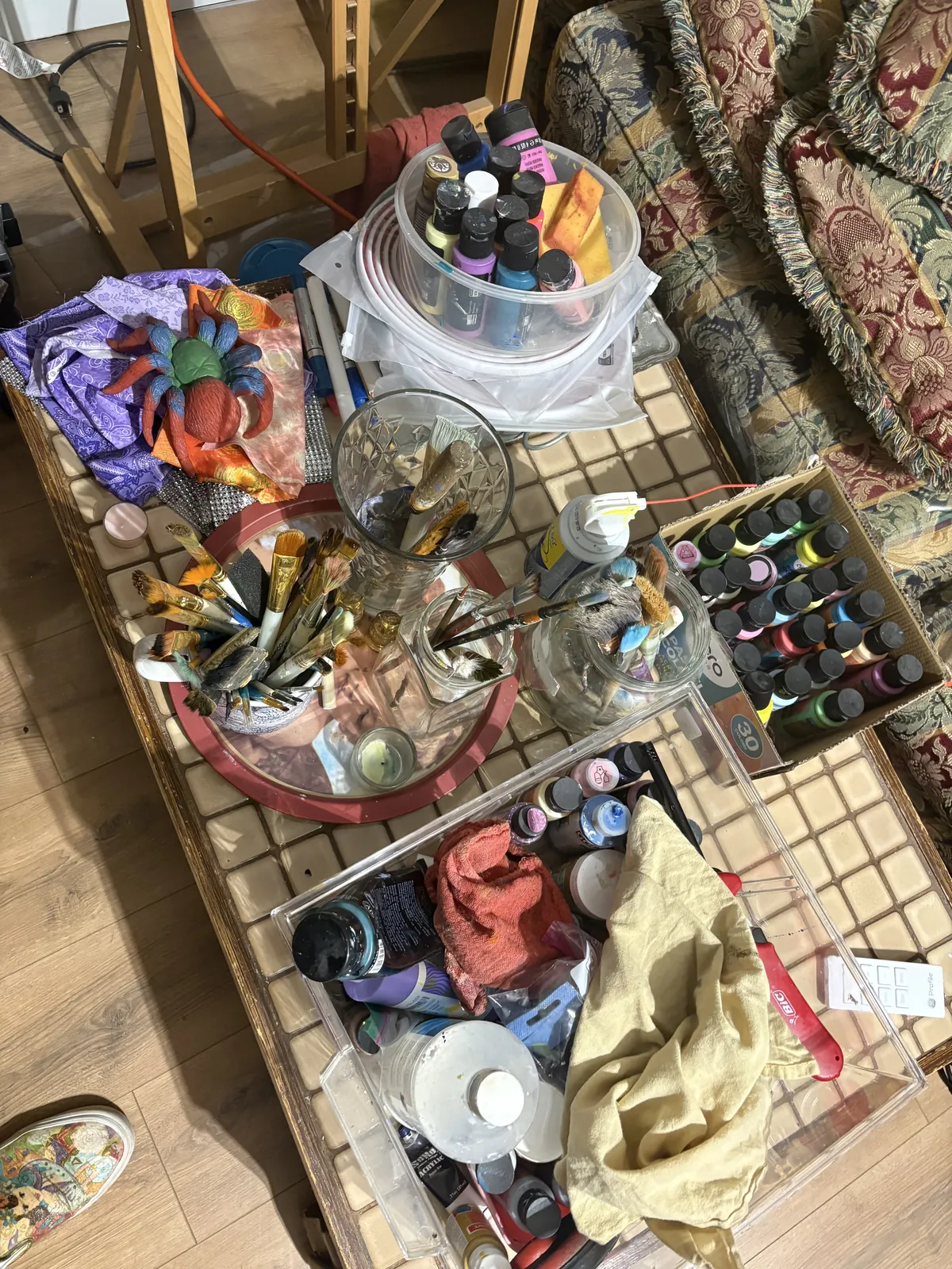 Agata May'kowska's messy paint table covered in acrylic tubes, brushes and palettes