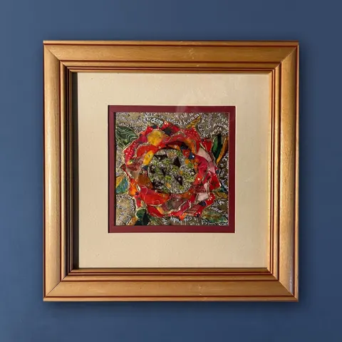 Sold original by Agata May'kowska — Colorful abstract artwork of a flower in a gold frame on a blue wall.