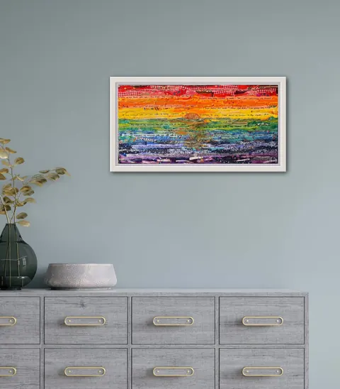 Sold original by Agata May'kowska — Colorful abstract painting with rainbow colors hung on a gray wall above a gray wooden sideboard with gold handles, decorated with a green vase with dried leaves and a…